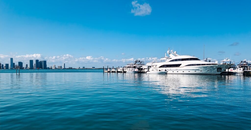 Luxury yacht docked at Miami Beach with Biscayne Bay and Miami skyline in the background